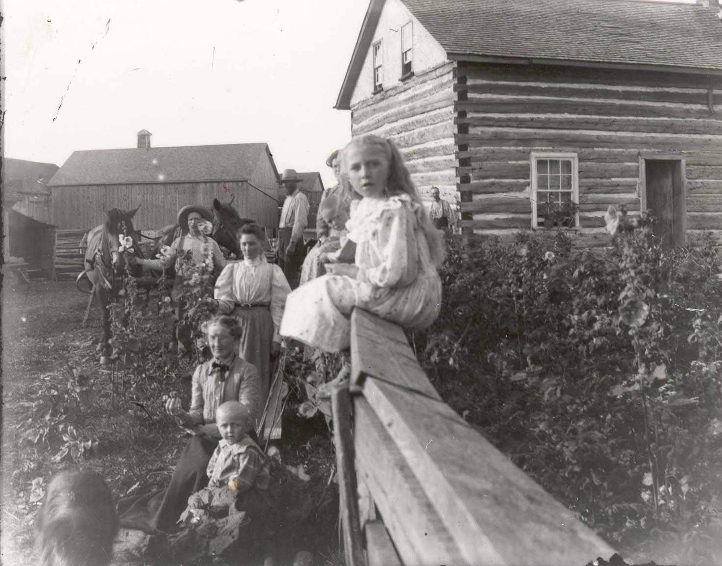 Unidentified%20family%20in%20front%20of%20log%20frame%20house%20and%20farm